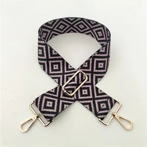Detail view of ethnic geometric diamond pattern shoulder strap with gold metal buckle