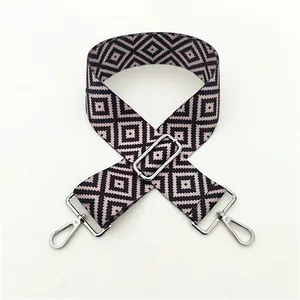 Detail of pink and black geometric woven purse strap with silver metal buckle