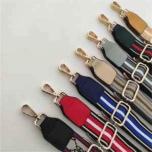 Detail view of colorful striped replacement bag straps with golden metal buckles and leather ends