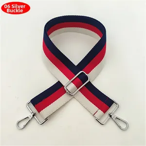 Detail of red, white and blue striped wide woven bag strap with silver metal buckles