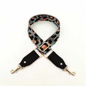 Détail de la bandoulière léopard réglable avec embouts en cuir noir et crochets dorés