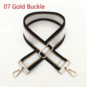 Close-up of black, white and gold striped wide shoulder strap with golden metal buckle