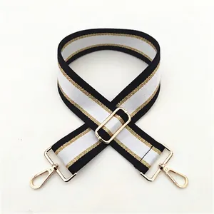 Detail of adjustable black and white striped woven bag strap with metal buckle