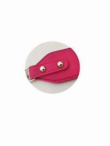 Close-up of magenta lychee grain leather bag strap with gold rivets and D-ring