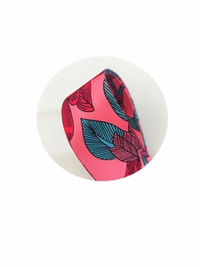 Detailed close-up of pink ribbon with tropical leaf patterns and ribbed texture for bags