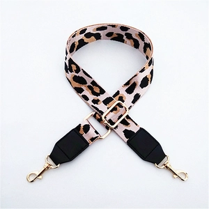 Detail of adjustable leopard print nylon strap with gold hooks and leather trim