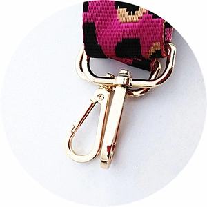 Macro view of leopard print bag strap featuring a polished golden swivel metal hook