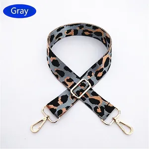 Close-up of gray leopard print adjustable bag strap with durable gold metal buckles
