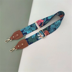 Detail of adjustable floral strap with blue and green patterns and golden metal hooks