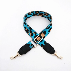 Macro detail of leopard print bag strap with durable blue webbing and golden metal hooks
