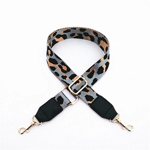 Close-up of leopard print bag strap with adjustable gold buckle and swivel lobster hooks