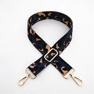 Close-up of leopard print canvas bag strap with golden metal lobster clasps