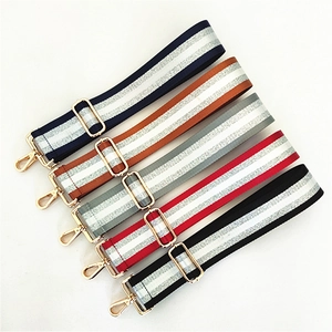 Detail of adjustable wide woven shoulder straps with silver threads and gold hardware