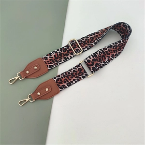 Detail of adjustable leopard print bag strap with gold metal hooks and leather accents