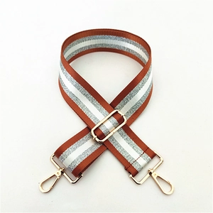 Macro view of adjustable brown and silver striped strap with golden lobster clasps