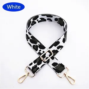 Close-up of leopard print shoulder strap with gold metal buckles and adjustable hardware