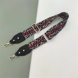 Detail of adjustable leopard print bag strap with golden metal hooks and leather ends