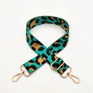 Detail of adjustable turquoise leopard print canvas bag strap with gold metal hooks