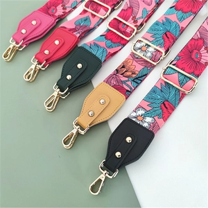 Detail of colorful floral pattern canvas bag straps with gold metal clasps and leather ends