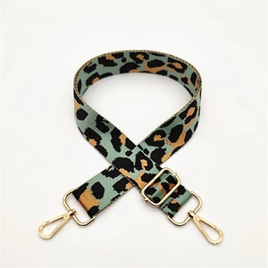 Detail of adjustable leopard print bag strap with mint green patterns and gold metal hooks