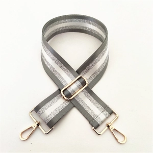 Close-up of adjustable striped nylon strap with silver glitter and gold metal clasps