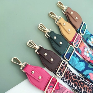 Detail showing adjustable wide shoulder straps with gold metal hooks and floral patterns