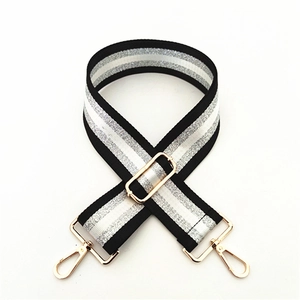 Detail of adjustable black and silver striped bag strap with gold lobster clasps