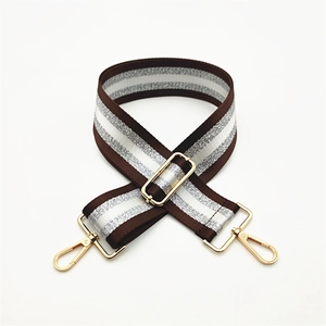 Detail of adjustable wide woven bag strap with silver metallic thread and gold lobster clasps