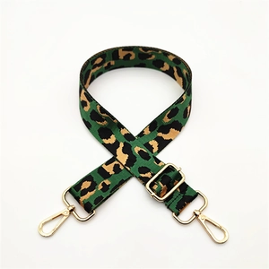 Leopard print crossbody strap with green accents and gold adjustable metal hardware
