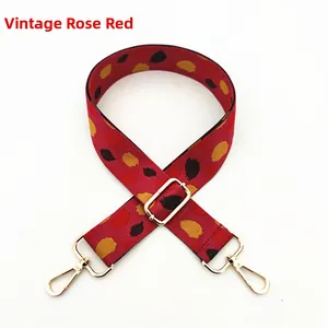 Macro detail of retro rose red bag strap with colorful dots and gold swivel hooks