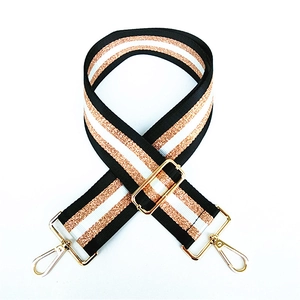 Detail of adjustable wide shoulder strap with rose gold metallic stripes and golden hooks