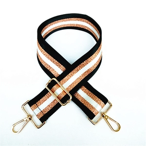Close-up of adjustable striped woven strap with sparkling threads and gold metal hardware