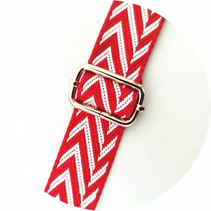 Detail of red and white chevron woven strap with adjustable light gold metal buckle