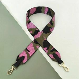 Close-up of pink and green ethnic pattern jacquard bag strap with gold metal hooks