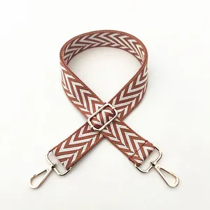 Detailed close-up of brown herringbone woven strap with light gold metal hardware