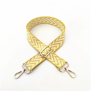 Detail of adjustable yellow and white chevron woven strap with golden metal swivel hooks