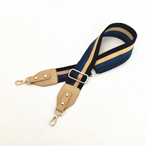 Détail de la bandoulière réglable rayée bleu marine et beige avec mousquetons dorés