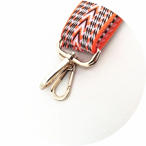 Macro detail of ethnic style thick cotton woven strap with gold metal lobster clasp