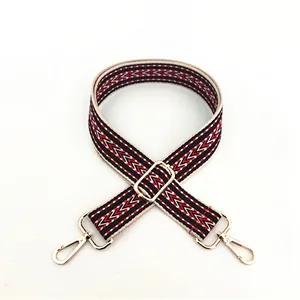 Macro detail of red and black geometric woven strap with gold metal swivel lobster clasps