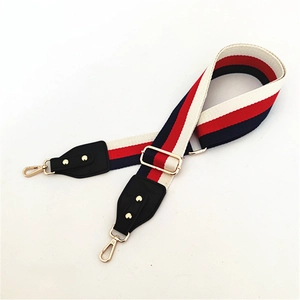 Detail eines verstellbaren Taschenriemens in Rot Weiß Blau mit goldener Hardware