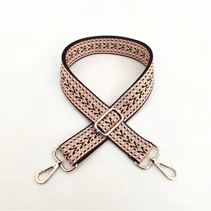 Close-up of ethnic geometric jacquard strap with golden lobster clasps and metal buckle