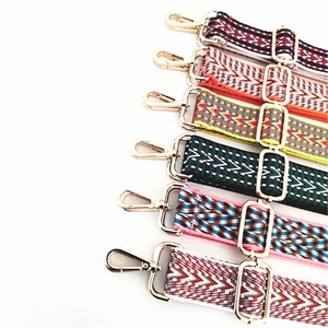 Close-up of bohemian style woven bag straps with colorful patterns and golden metal hardware