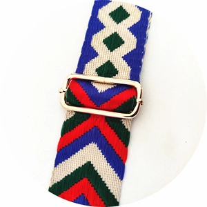 Close-up of colorful ethnic woven strap with geometric patterns and gold metal buckle