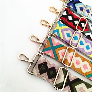 Close-up of bohemian woven bag straps with geometric patterns and gold metal hooks