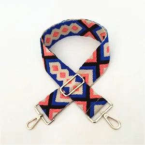 Detail of adjustable geometric jacquard strap with gold-tone swivel hooks and woven patterns