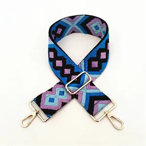Close-up of ethnic geometric embroidered bag strap with golden metal swivel hooks