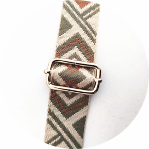 Close-up of ethnic geometric woven strap with gold metal buckle for bags