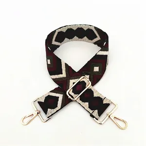 Detail of adjustable geometric diamond pattern shoulder strap with gold metal lobster clasps