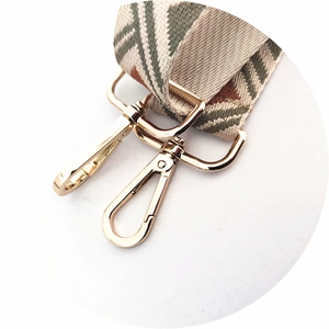 Close-up of geometric ethnic woven strap with polished gold hardware and lobster clasps