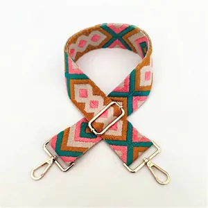 Detail of colorful geometric embroidery on ethnic style shoulder strap with gold buckles